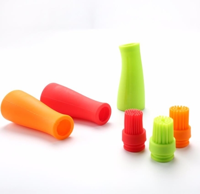 O assado do produto comestível utiliza ferramentas a garrafa branca do óleo de silicone com escova colorida